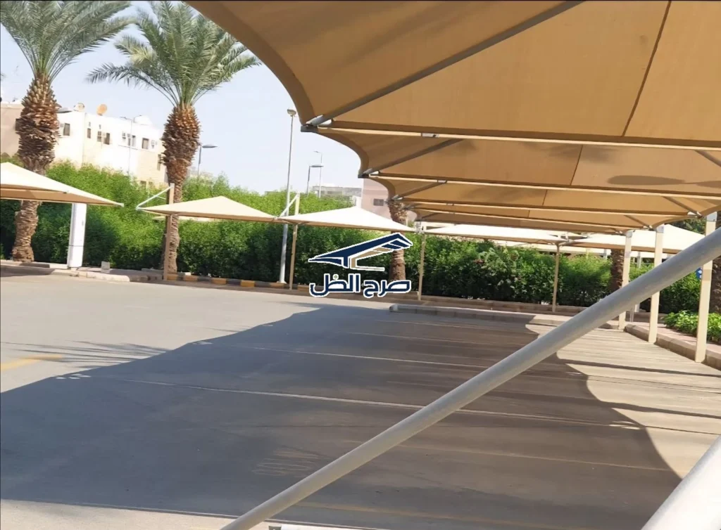 مظلات مواقف سيارات بجوار أشجار ومسار حركة