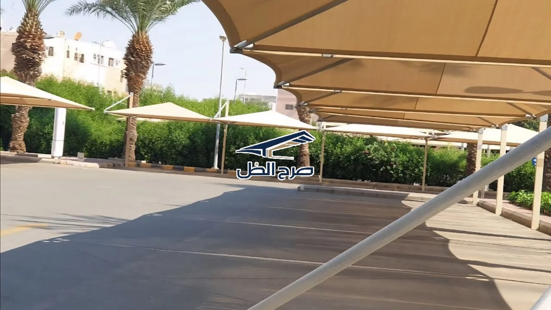 مظلات مواقف سيارات بجوار أشجار ومسار حركة