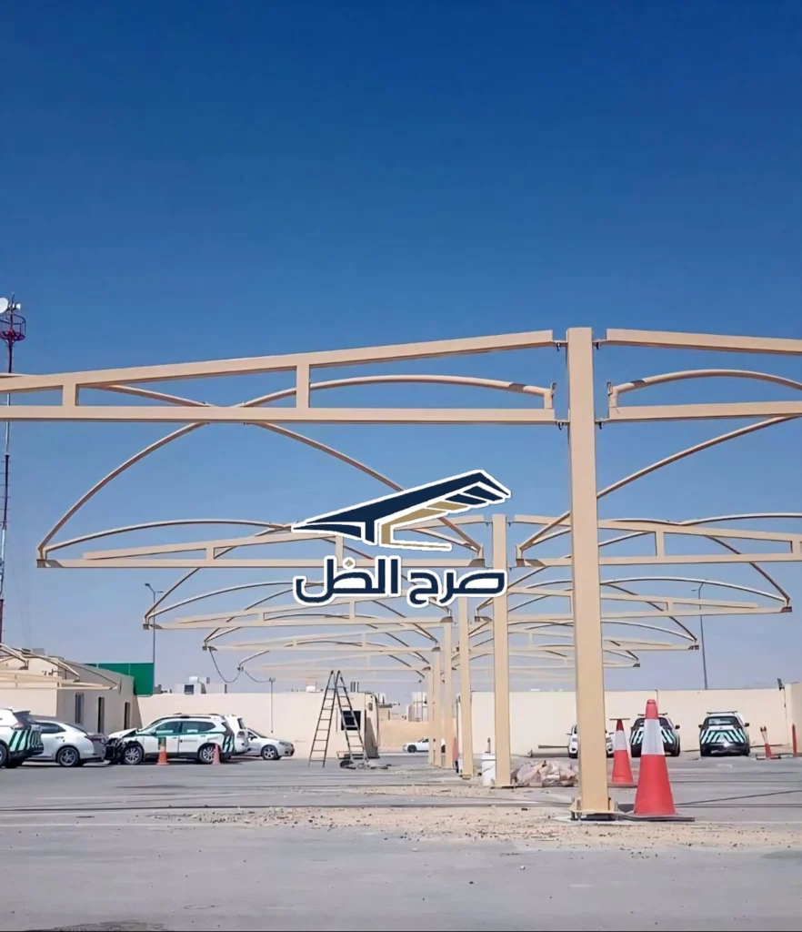 هيكل مظلات مواقف ممتد في مساحة مفتوحة نهارية.