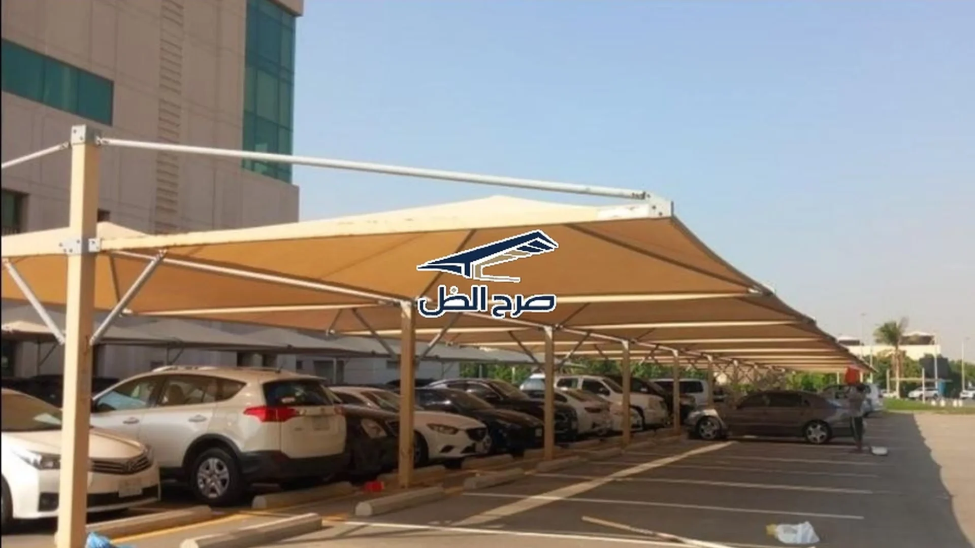 مظلات مواقف سيارات طويلة بجوار مبنى