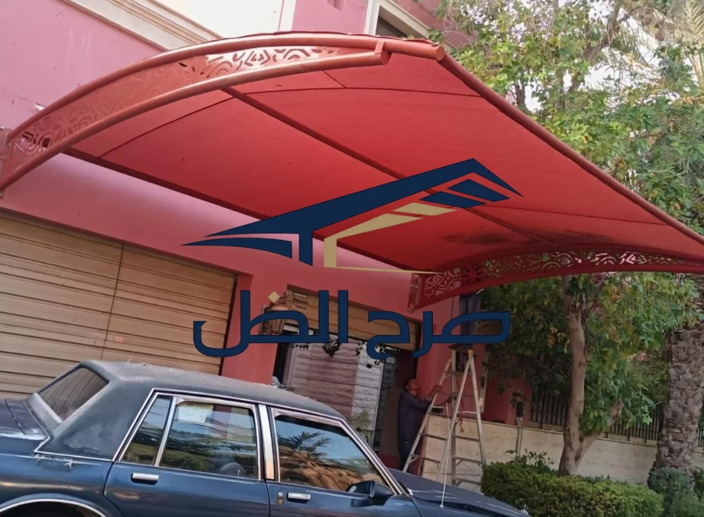 مظلة حمراء فوق مساحة خارجية بجوار مبنى.