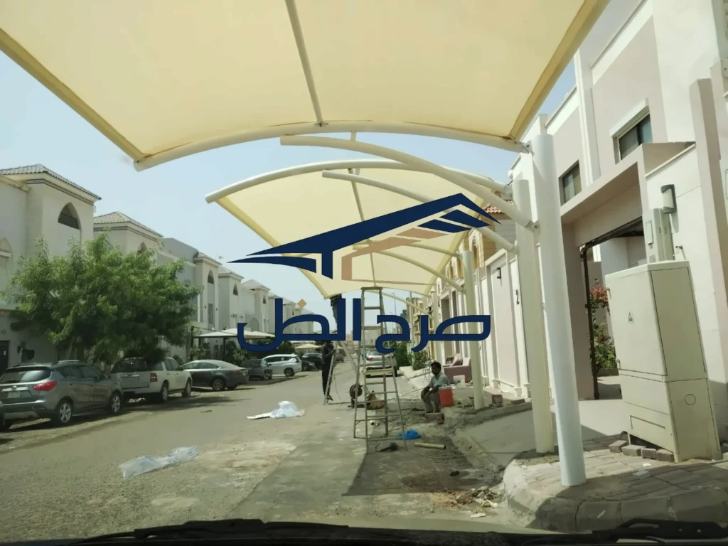 مظلة بمحاذاة منزل وفناء خارجي تحيط به الأشجار