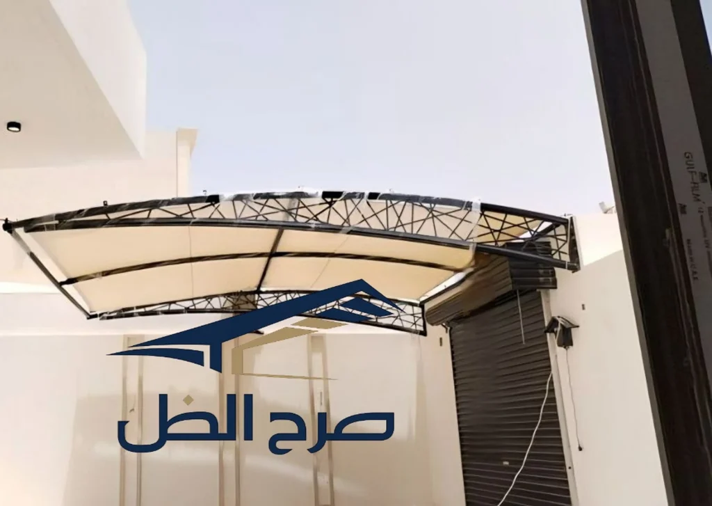 مظلة مدخل بلون فاتح أمام واجهة مبنى.