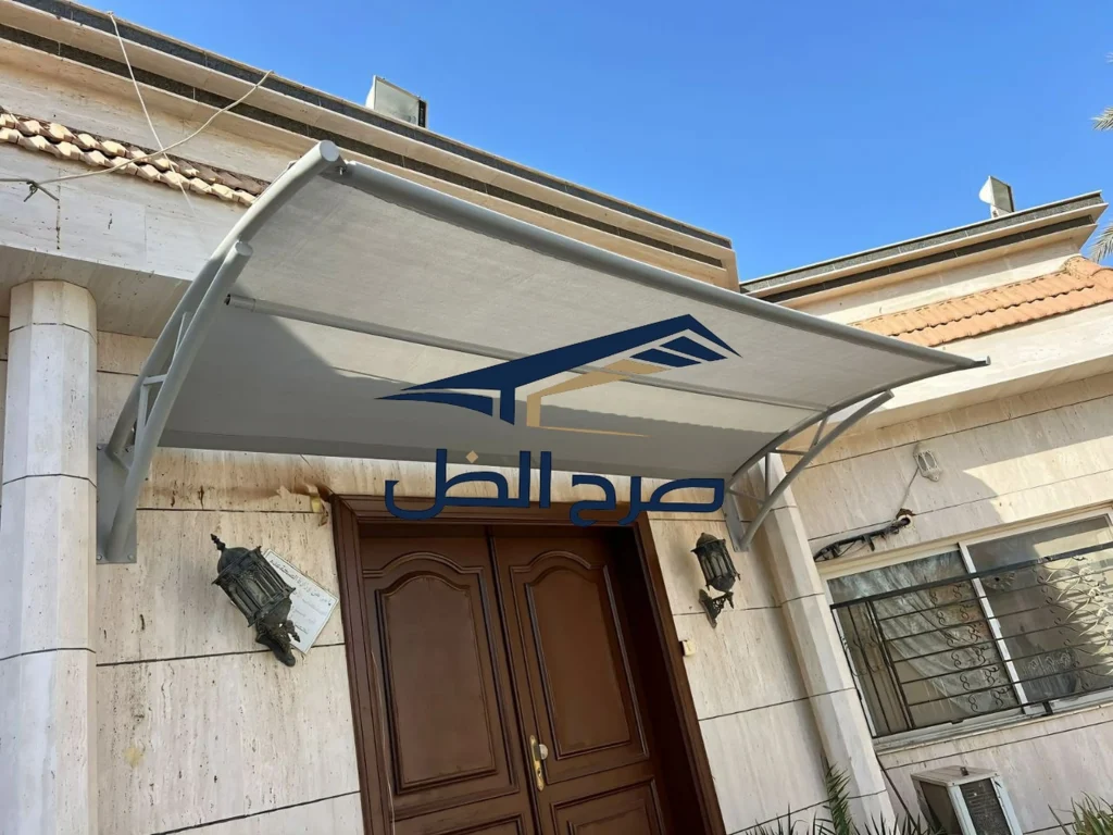 مظلة مثبتة فوق مدخل سكني مع حواف ودعامات واضحة.