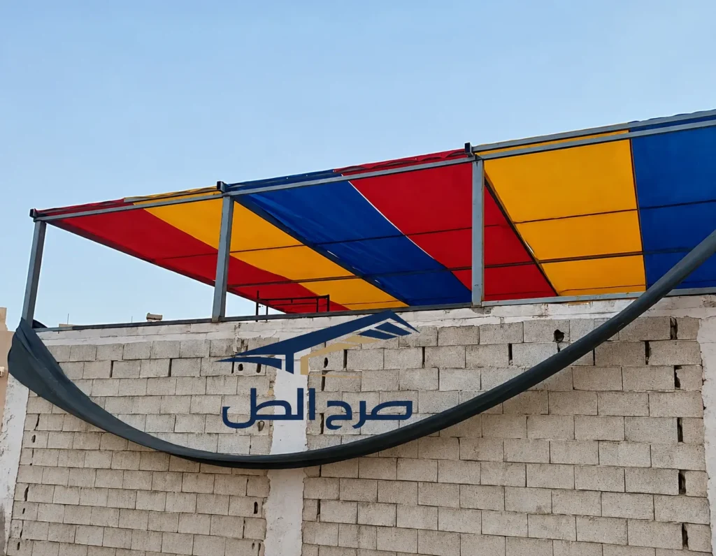مظلة خارجية بألوان متعددة فوق فناء أو جلسة.