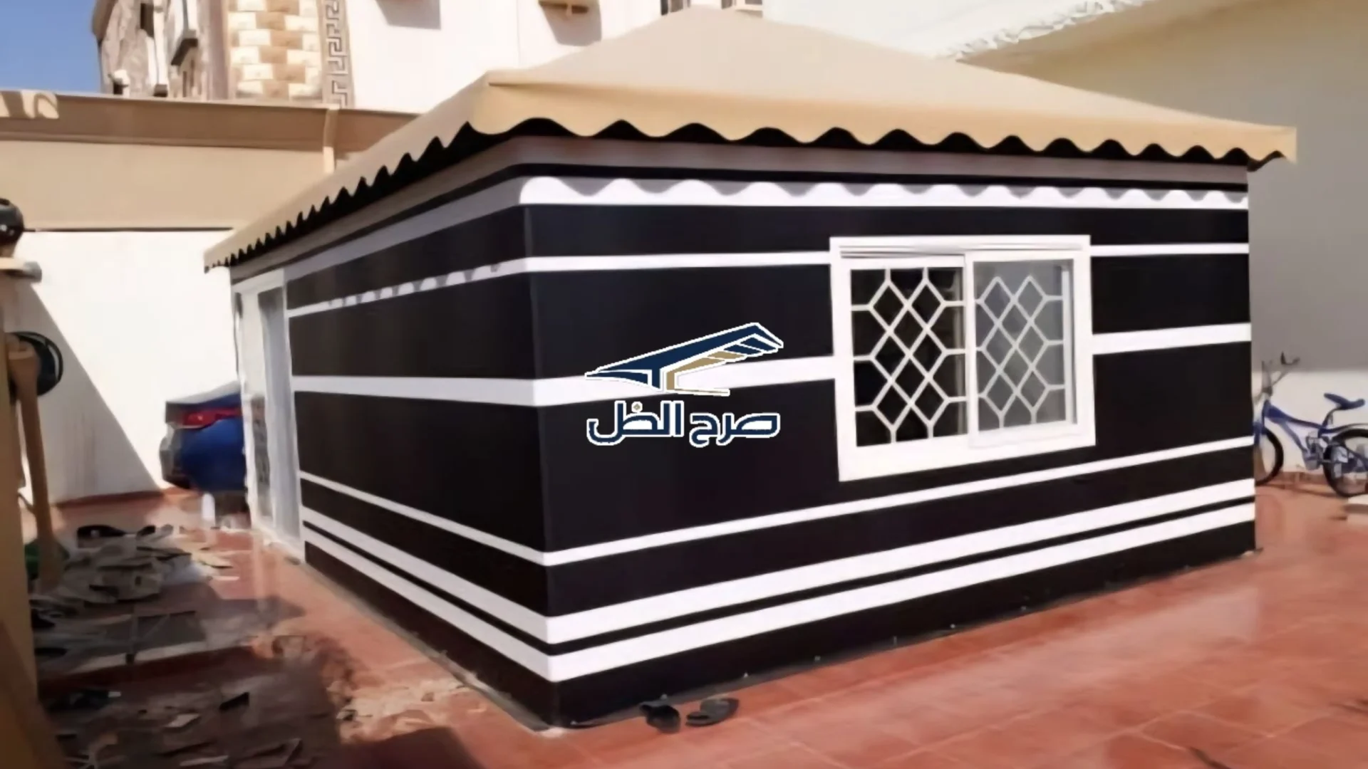 خيمة مجلس خارجية سوداء وبيضاء في فناء منزلي
